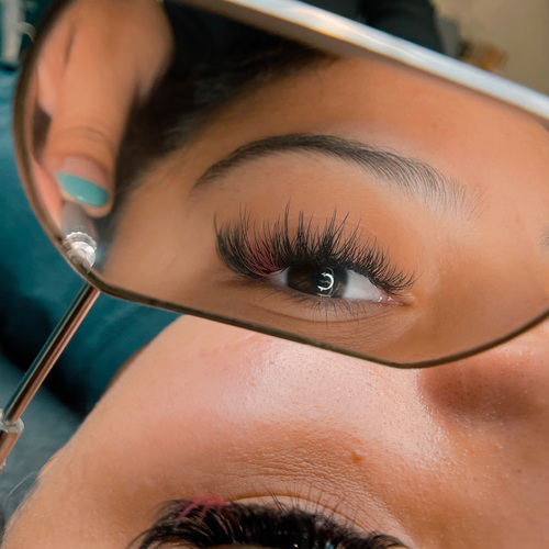 Volume lash extensions viewed through a hand mirror